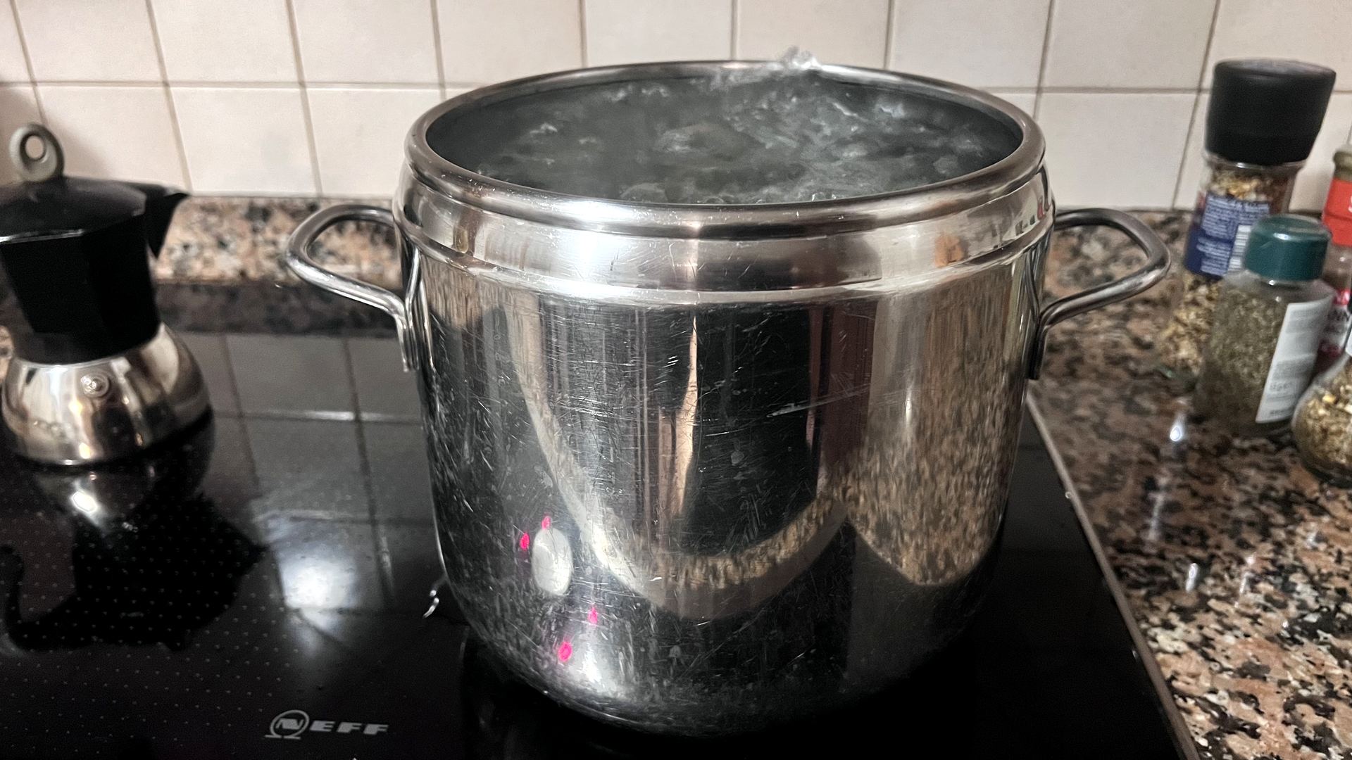 Pentola d'acqua in ebollizione su piano a induzione - l'energia elettrica si trasforma in calore, ed è proprio questo che misura il kilowattora.