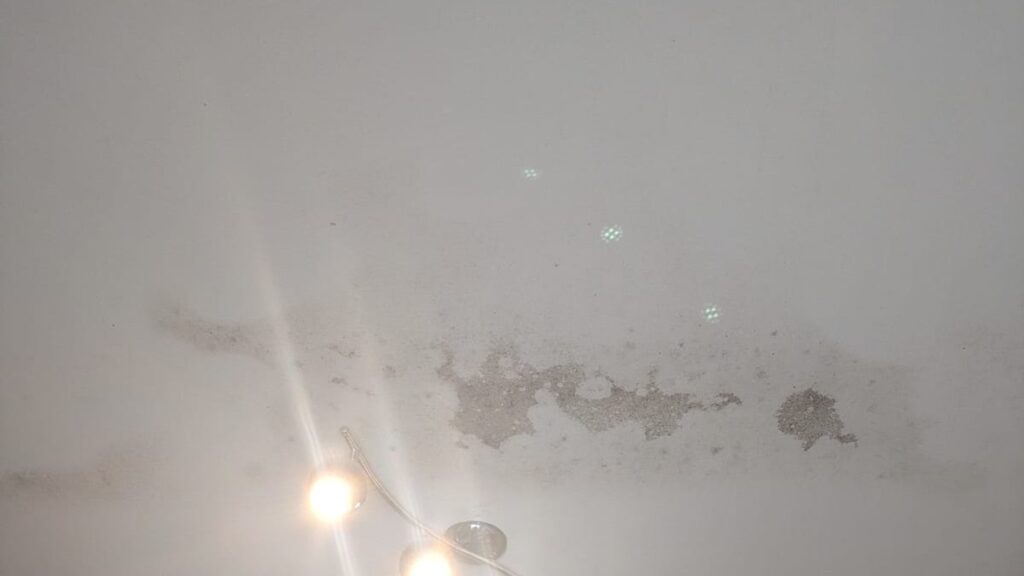 Macchie di muffa e condensa su un soffitto domestico causate da dispersioni termiche attraverso la copertura non isolata