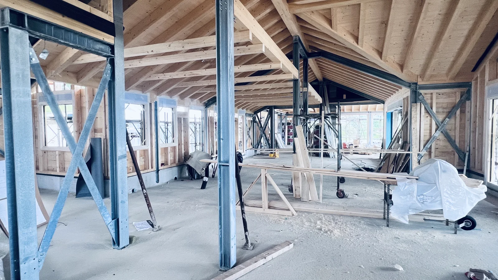 Vista interna del cantiere di Acciaio, legno e aria a Chies d'Alpago: la struttura ibrida con pilastri in acciaio e orditura del tetto in legno lamellare