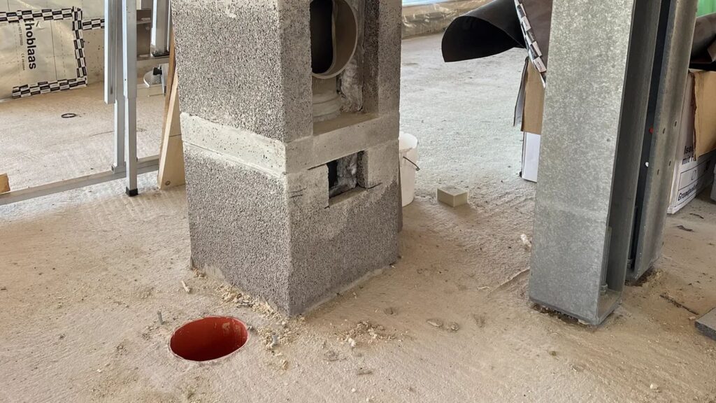 Base del camino con apertura tonda per il raccordo e bocca arancione del condotto dell’aria comburente a filo del massetto.