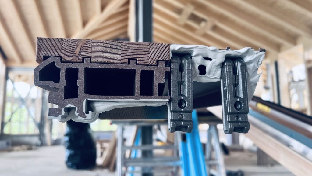 Sezione del profilo a taglio termico della soglia di un serramento legno-alluminio con isolamento interno.
