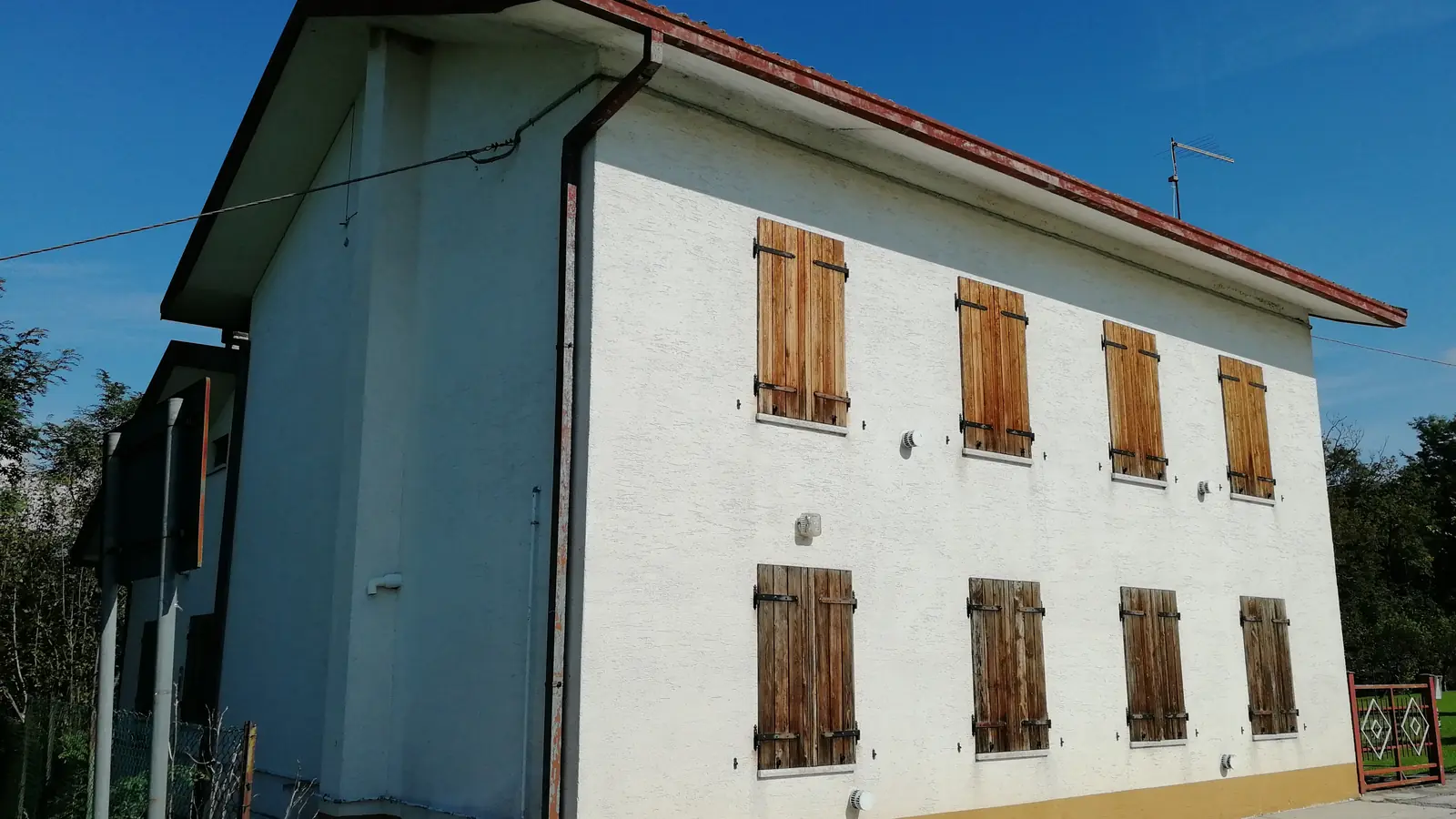 Casa a due piani nel Bellunese con gli scuri in legno chiusi